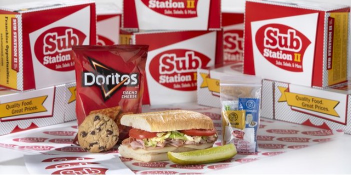 A Sub Station II box meal with a sub, chips, a cookie, a pickle and condiments